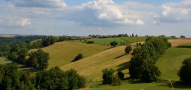 Hügellandschaft mit Dorf im Hintergrung